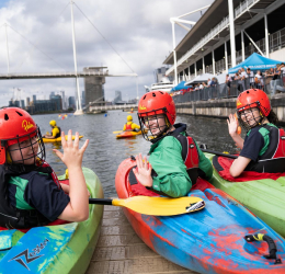 Kayakers wave to the camera on the dock.