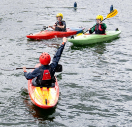 Kayakers playing a ball game on the dock.