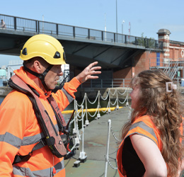 Two team members talk on the dock.
