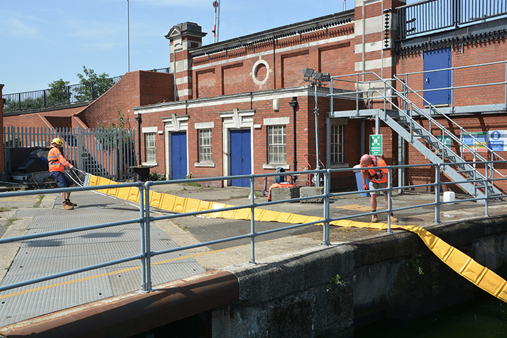 Two team members in hi-vis doing oil spill training.