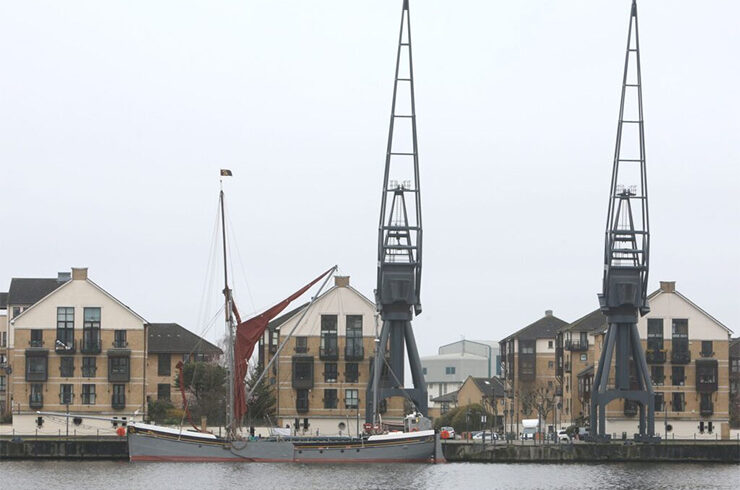 Dock cranes lined along the side of a dock.