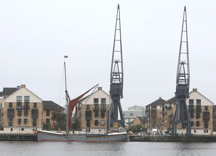 Dock cranes lined along the side of a dock.